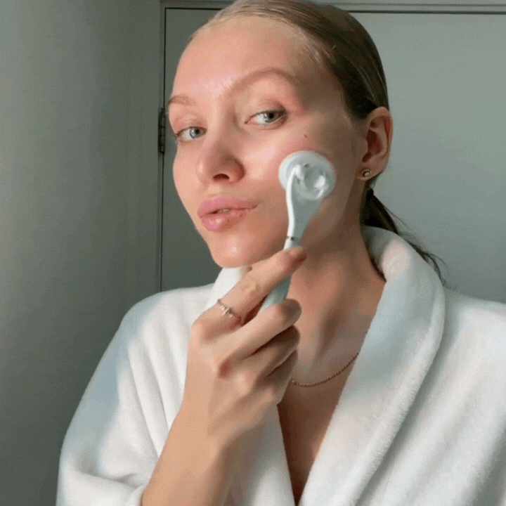 gif of woman applying skincare with LUNAESCENT and smiling