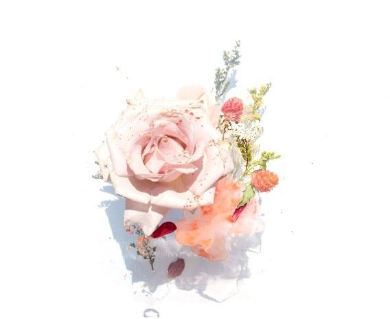 An image of a pink rose surrounded by smaller flowers.